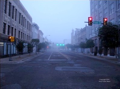 A downtown street on a foggy morning