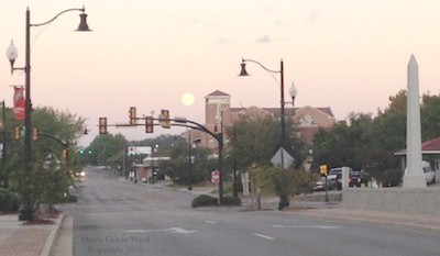 Moon setting in the downtown business district