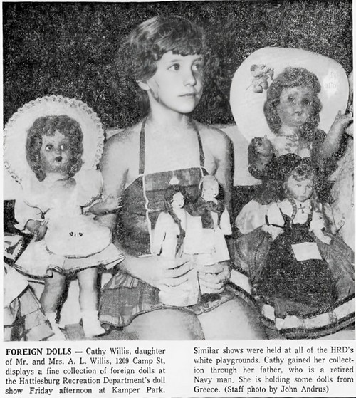 A child sits with her dolls