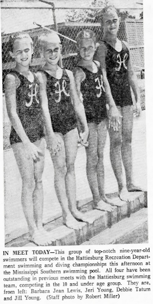 Children standing next to a swimming pool