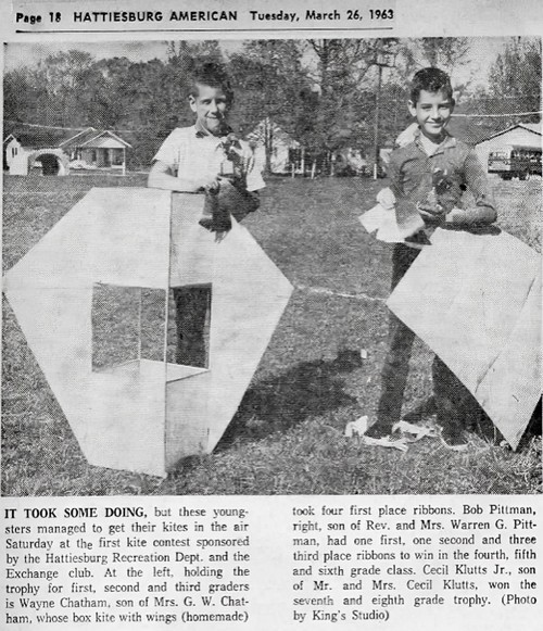 Two boys pose with their kites